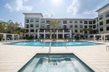 Pool deck with hot tub and apartment buildings